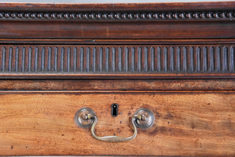 A late eighteenth-century mahogany chest on chest featuring upper and lower drawer sections with brass handles and carved bracket feet. View V