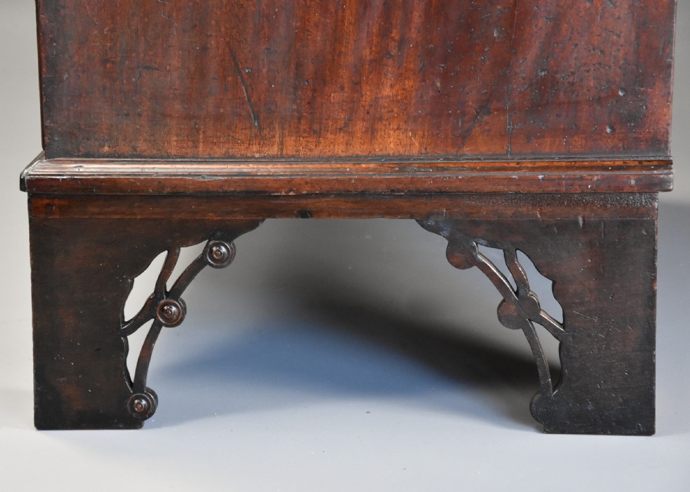 A late eighteenth-century mahogany chest on chest featuring upper and lower drawer sections with brass handles and carved bracket feet. View XII