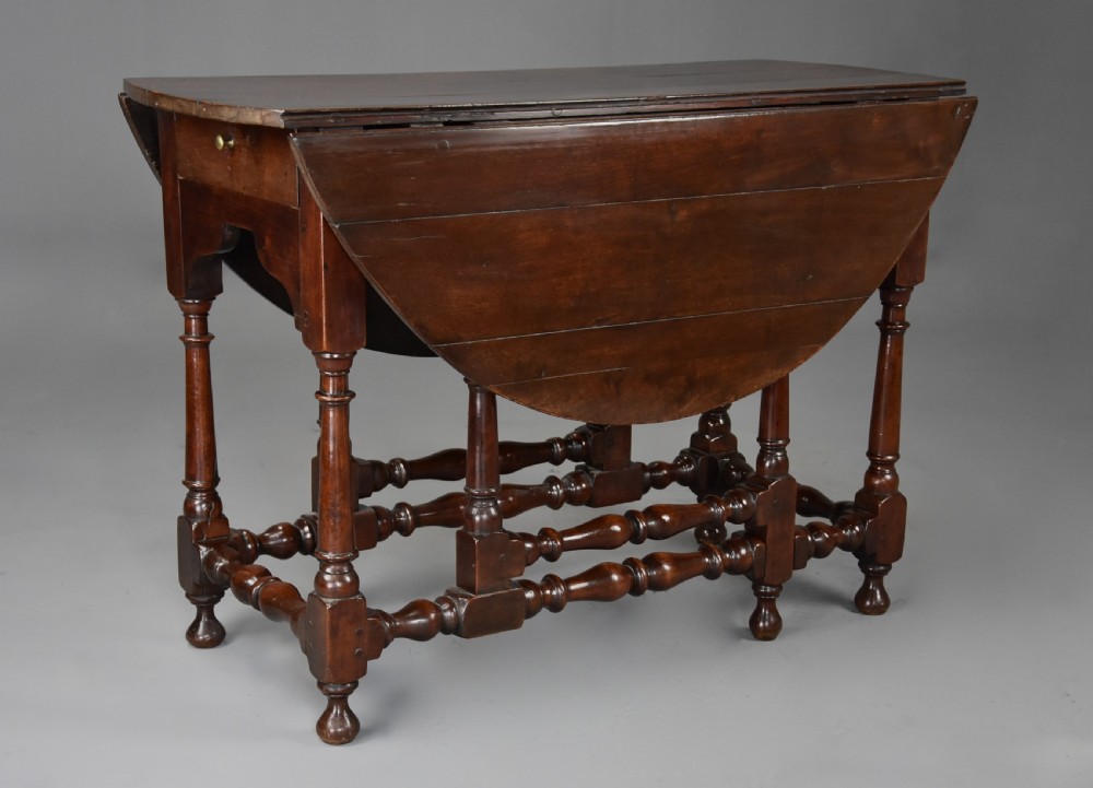 An 18th-century dark walnut gateleg table with folding drop leaves, turned supports, and lower stretchers. View III