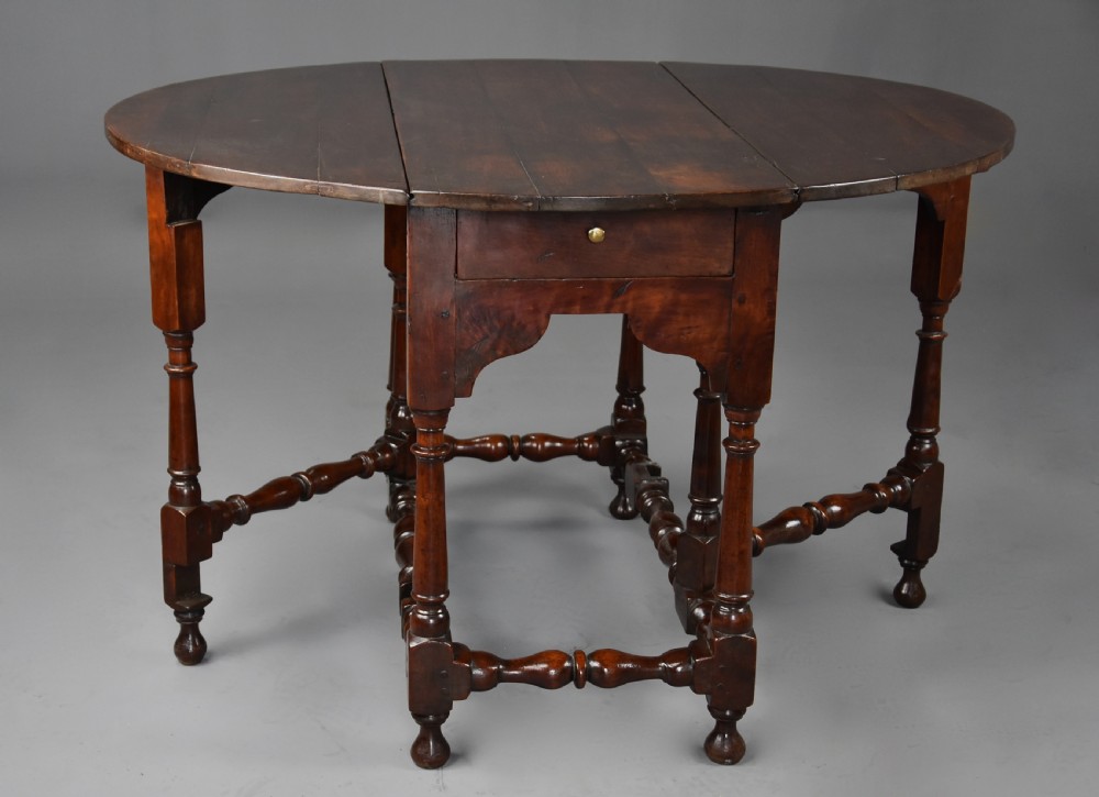 An 18th-century dark walnut gateleg table with folding drop leaves, turned supports, and lower stretchers. View X