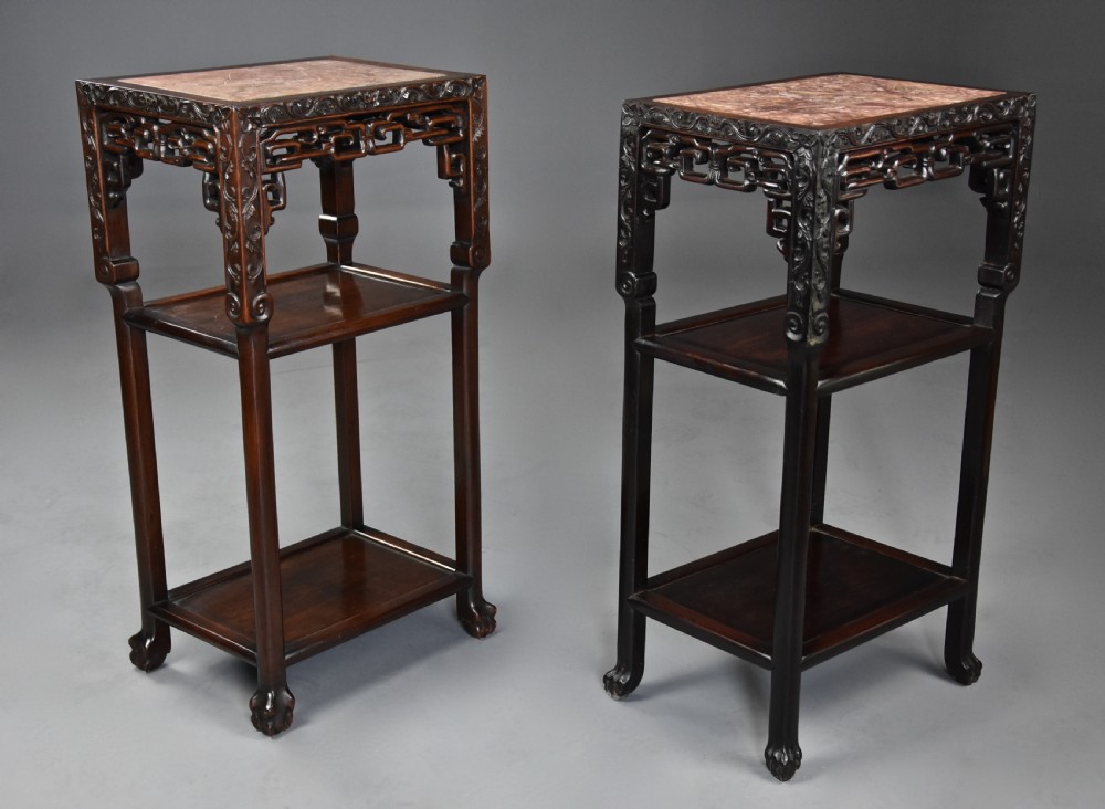 A matched pair of late nineteenth-century Chinese dark hardwood plant stands featuring inset marble tops, carved openwork aprons, and two lower tiers. View III
