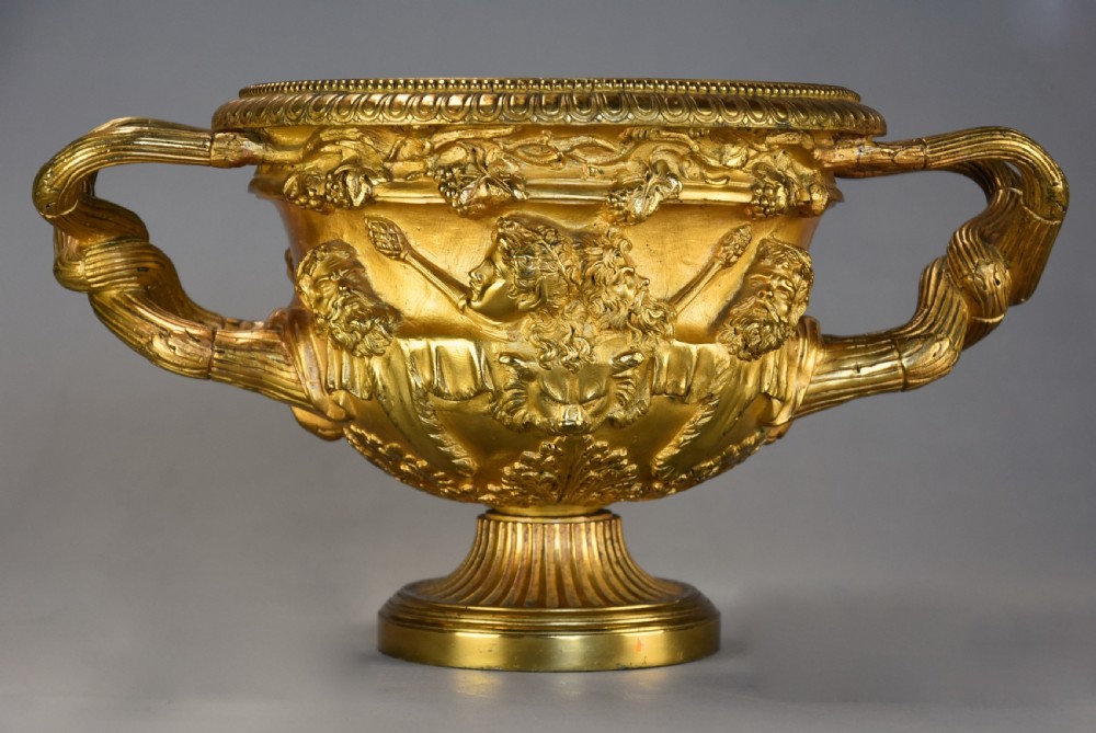 A 19th-century gilt bronze reduction of the Warwick Vase featuring high-relief Bacchic masks, intertwined vine handles, and a pedestal base. View III