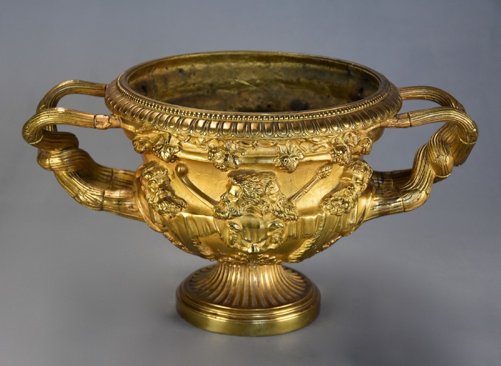 A 19th-century gilt bronze reduction of the Warwick Vase featuring high-relief Bacchic masks, intertwined vine handles, and a pedestal base. View IV
