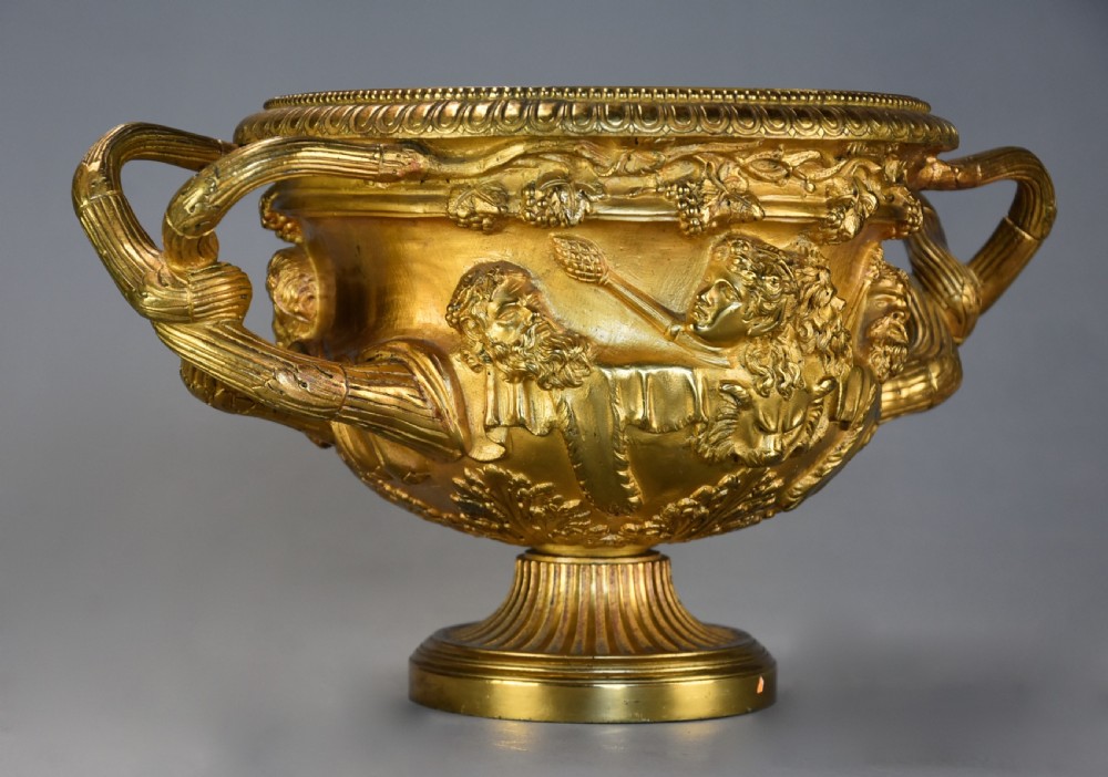 A 19th-century gilt bronze reduction of the Warwick Vase featuring high-relief Bacchic masks, intertwined vine handles, and a pedestal base. View VI