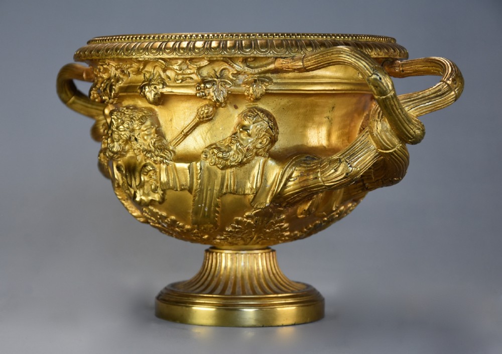 A 19th-century gilt bronze reduction of the Warwick Vase featuring high-relief Bacchic masks, intertwined vine handles, and a pedestal base. View VII