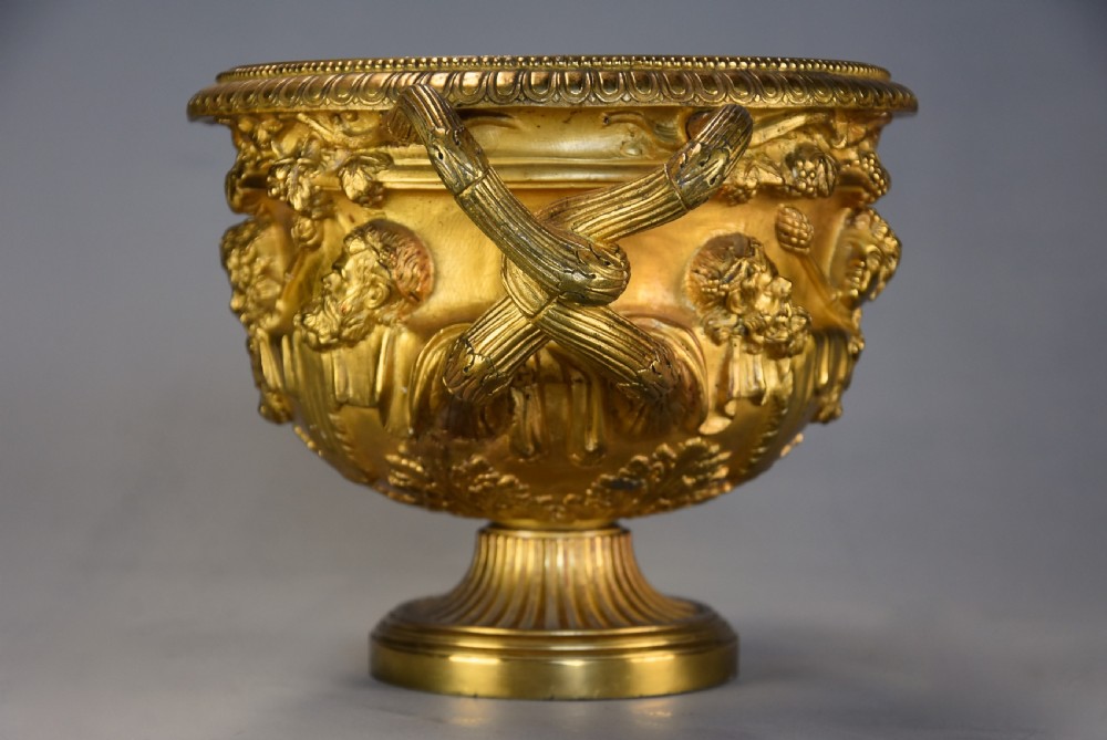 A 19th-century gilt bronze reduction of the Warwick Vase featuring high-relief Bacchic masks, intertwined vine handles, and a pedestal base. View XII