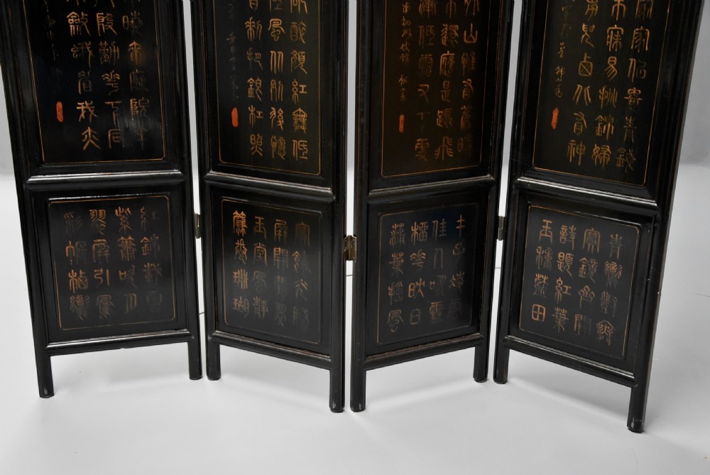 An early 20th-century Chinese four-panel folding screen finished in black lacquer with gilt painted birds, blossom branches, and calligraphic text. View XVI