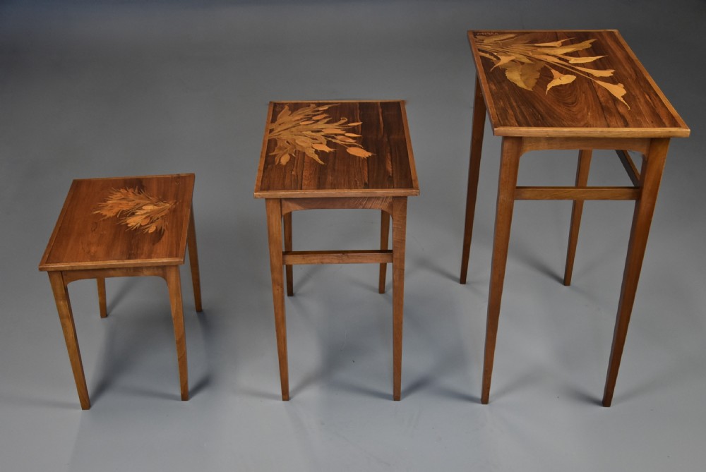 A set of three graduating French Art Nouveau rosewood nesting tables with floral marquetry tops and slender tapered legs. View IV