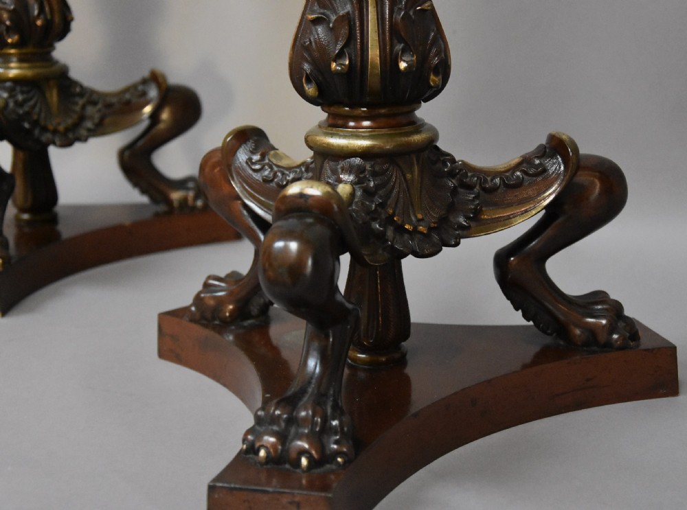 A pair of tall late 19th-century Regency style mahogany torcheres featuring fluted columns, ornate bronze monopodia legs, and triform bases. View IX