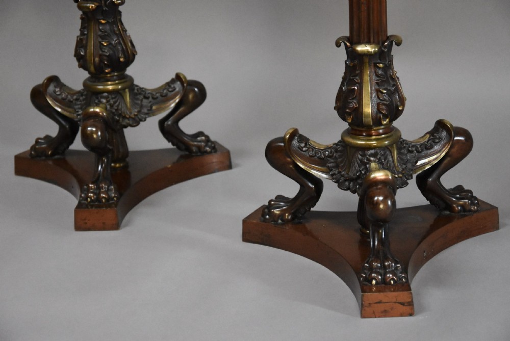 A pair of tall late 19th-century Regency style mahogany torcheres featuring fluted columns, ornate bronze monopodia legs, and triform bases. View XI