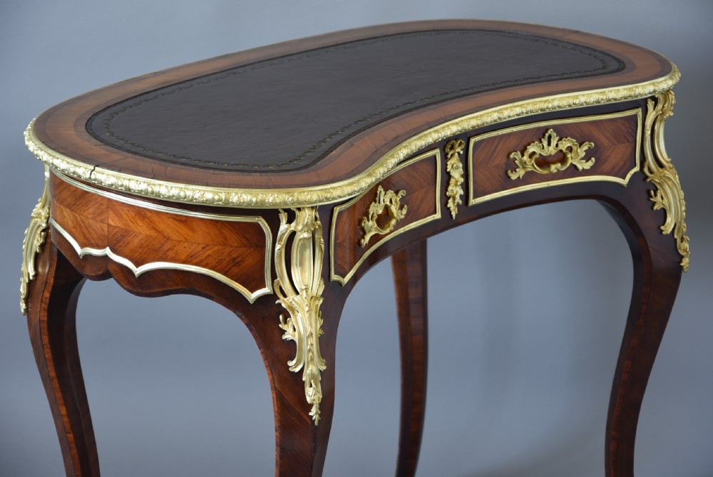 A 19th-century kidney-shaped kingwood writing desk featuring gilt-bronze ormolu mounts, a leather top, and curved cabriole legs. View VIII