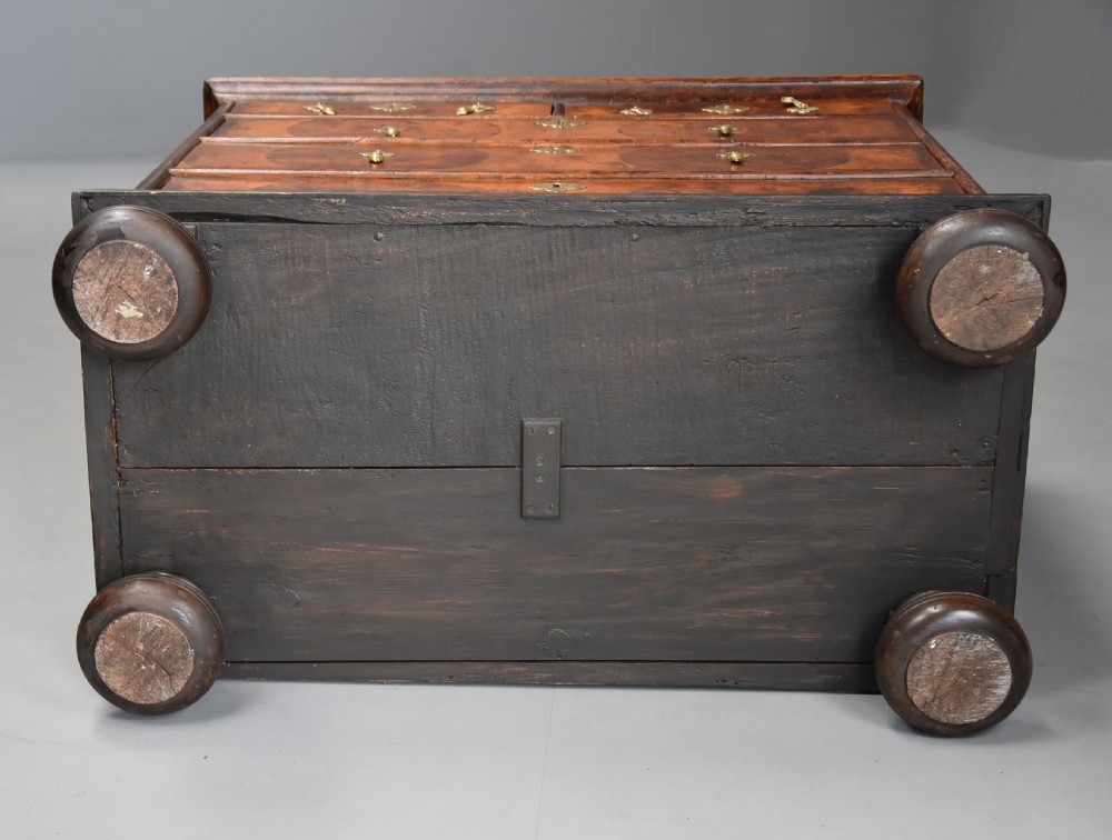 A late 17th-century William and Mary chest of drawers with oval yew wood veneers, brass teardrop handles, and dark turned bun feet. View XVI