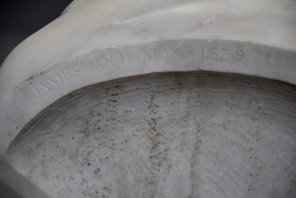 A carved white marble portrait bust of a gentleman wearing classical drapery mounted on a circular socle base. View XII