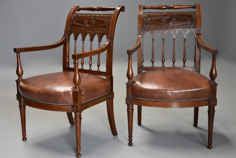 A pair of late 18th-century French Directoire style carved walnut open armchairs with studded brown leather seats. View II