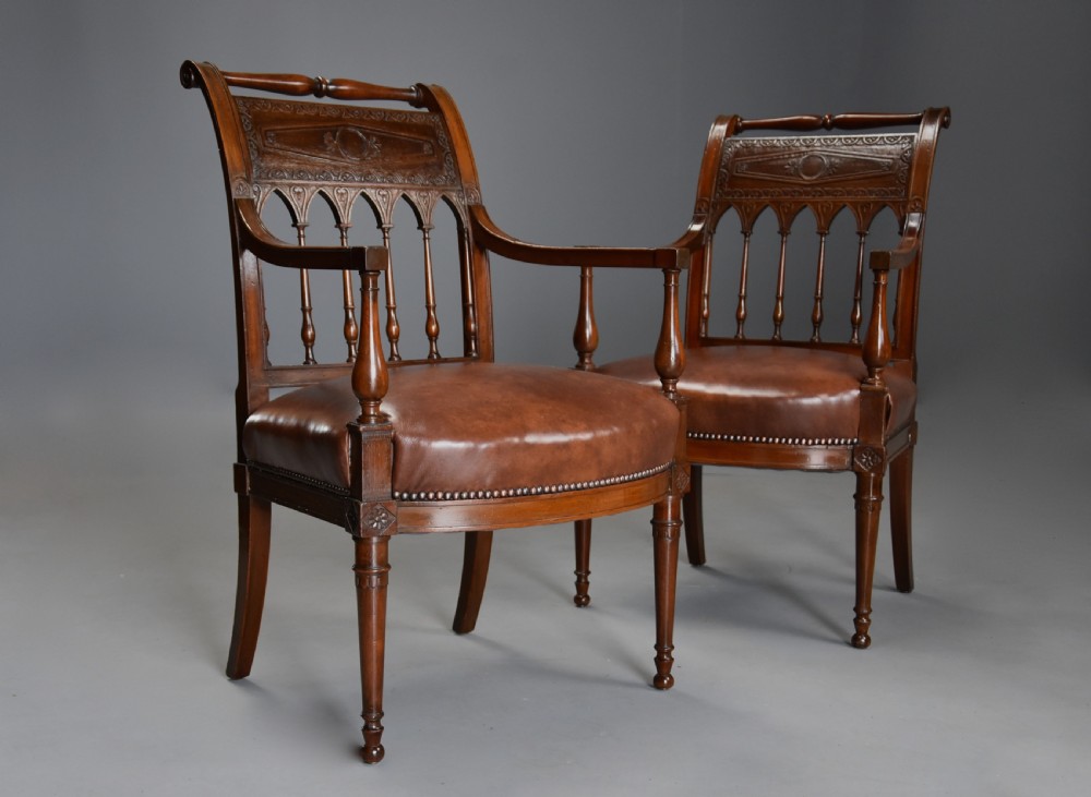 A pair of late 18th-century French Directoire style carved walnut open armchairs with studded brown leather seats. View VIII