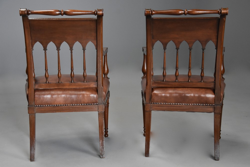 A pair of late 18th-century French Directoire style carved walnut open armchairs with studded brown leather seats. View XV
