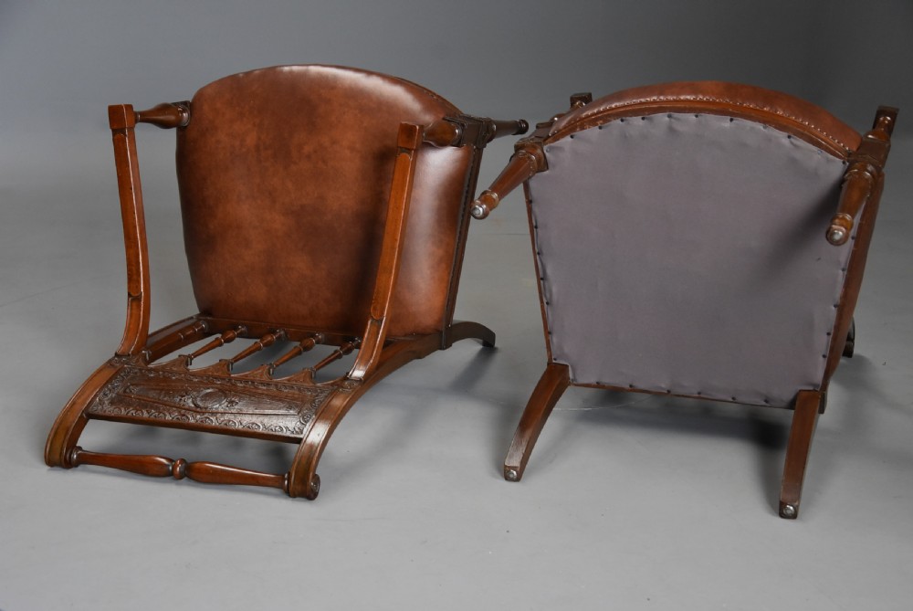 A pair of late 18th-century French Directoire style carved walnut open armchairs with studded brown leather seats. View XVI