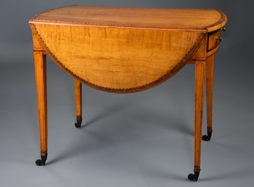 A late 18th-century Georgian Pembroke table made of fiddleback sycamore timber with two drop leaves, a single drawer with brass knobs, and tapered legs on brass castors. View VIII