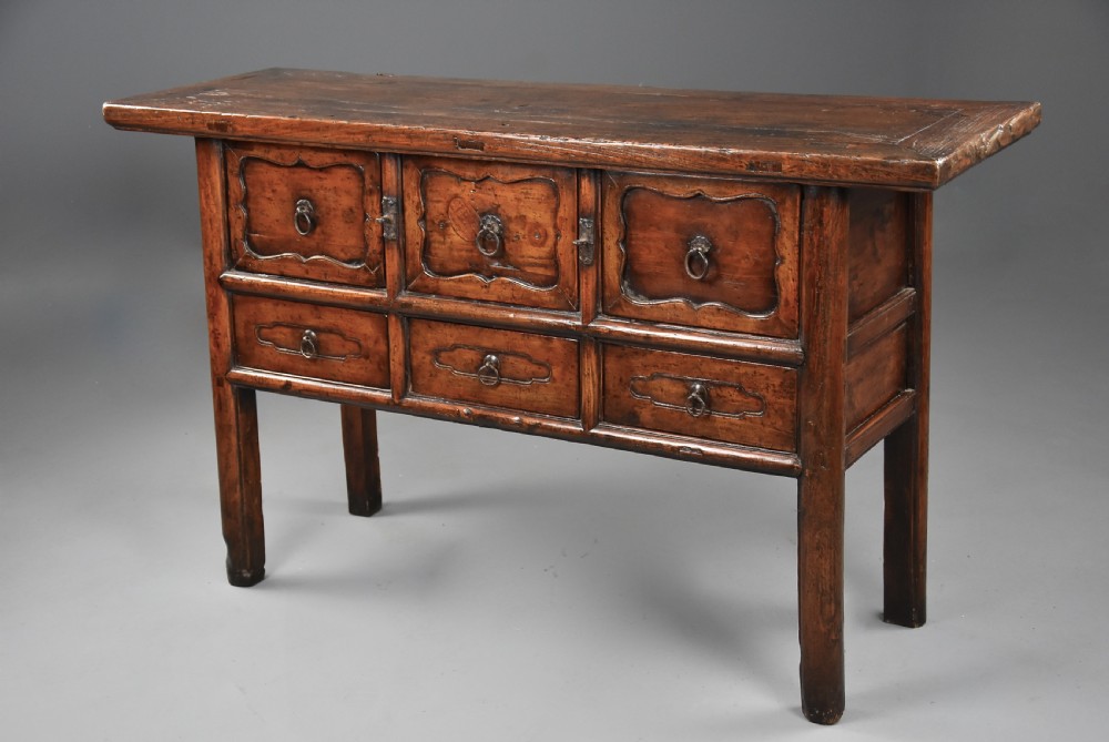 A late nineteenth-century rustic Chinese elm sideboard featuring three upper doors with contoured panels and three lower drawers fitted with metal ring pulls.