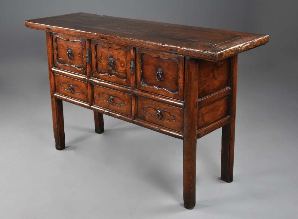 A late nineteenth-century rustic Chinese elm sideboard featuring three upper doors with contoured panels and three lower drawers fitted with metal ring pulls. View VI