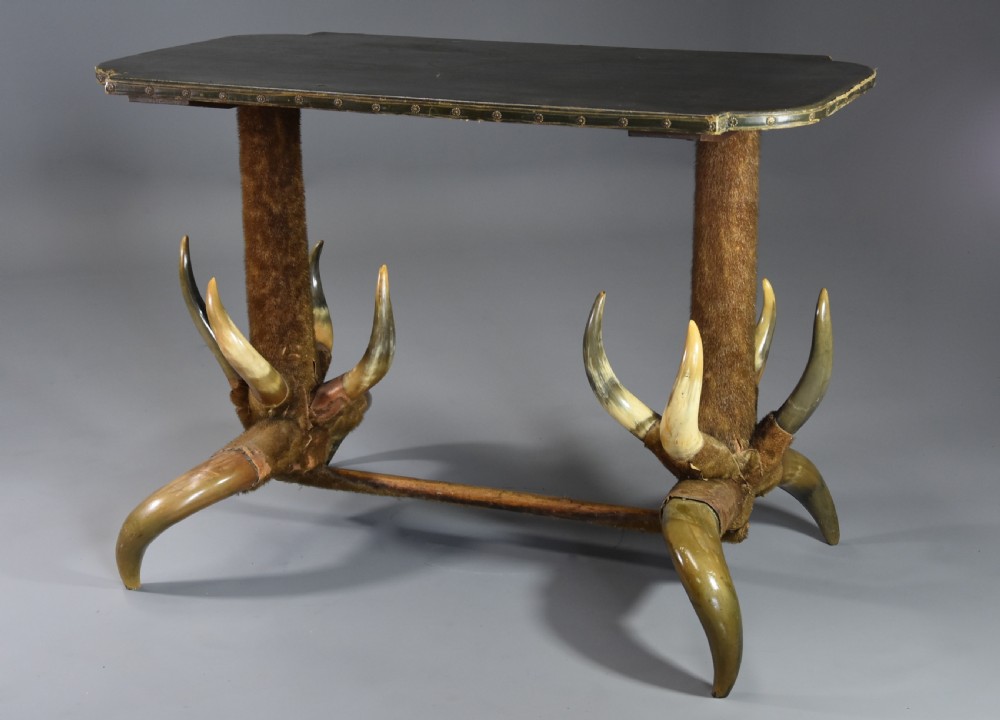 Late nineteenth-century German side table featuring a dark green leather studded top supported by fur-wrapped posts and natural cow horn legs.