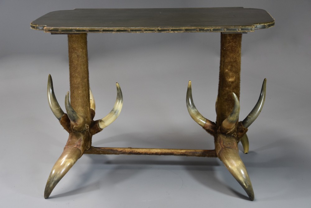 Late nineteenth-century German side table featuring a dark green leather studded top supported by fur-wrapped posts and natural cow horn legs. View II