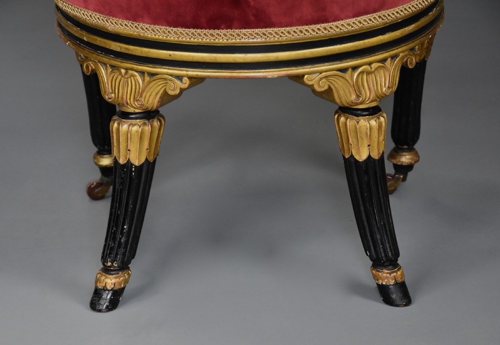 An early 19th-century Regency ebonised and gilt side chair upholstered in crimson velvet with reeded legs and brass castors. View X