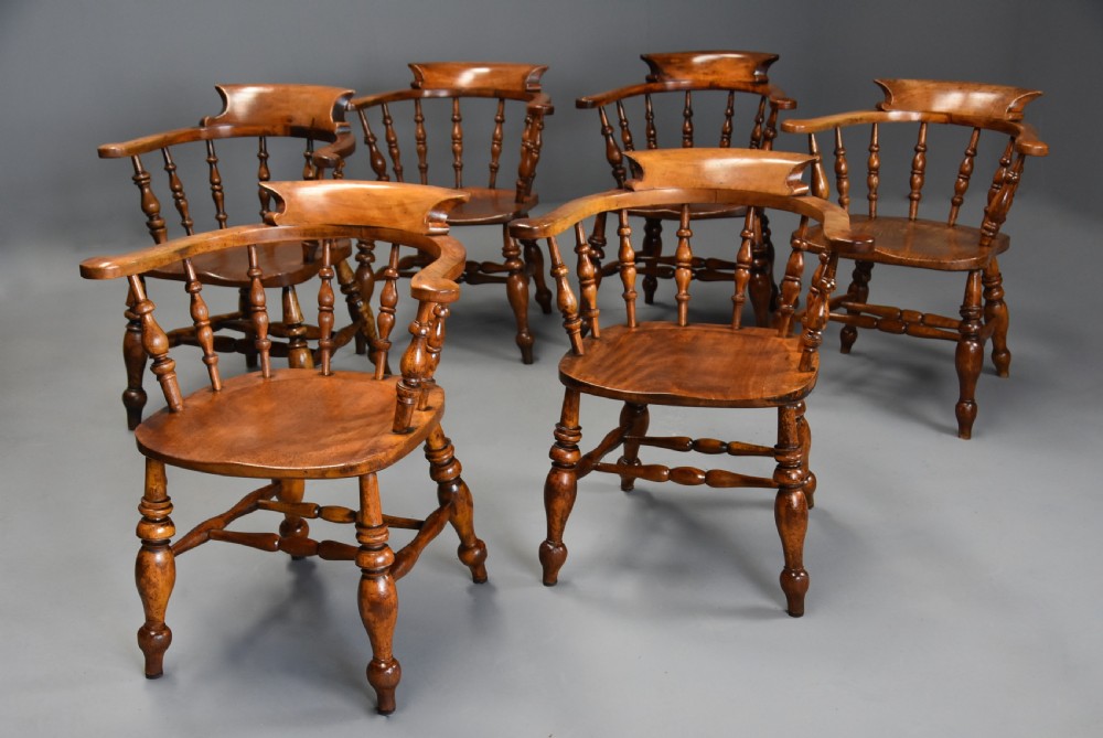 A set of six mid 19th century wooden smokers bow Windsor chairs with curved crest rails, turned spindles, shaped seats, and turned legs with stretchers. View II