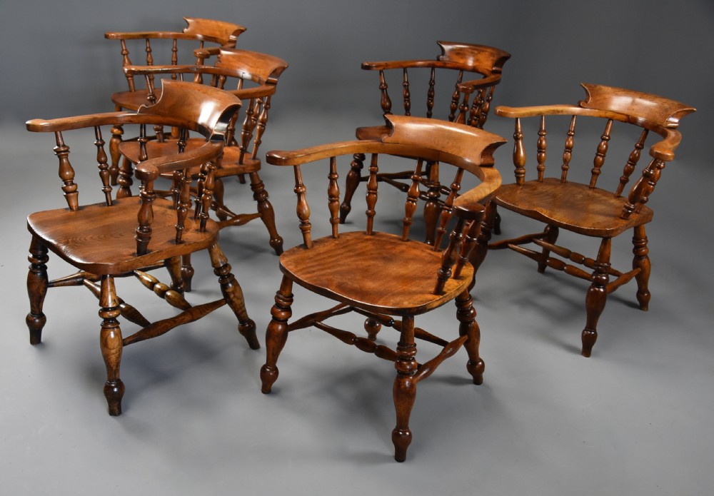 A set of six mid 19th century wooden smokers bow Windsor chairs with curved crest rails, turned spindles, shaped seats, and turned legs with stretchers. View III