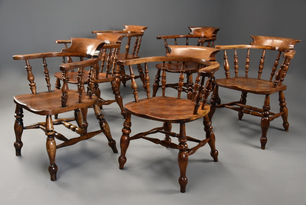 A set of six mid 19th century wooden smokers bow Windsor chairs with curved crest rails, turned spindles, shaped seats, and turned legs with stretchers. View IV