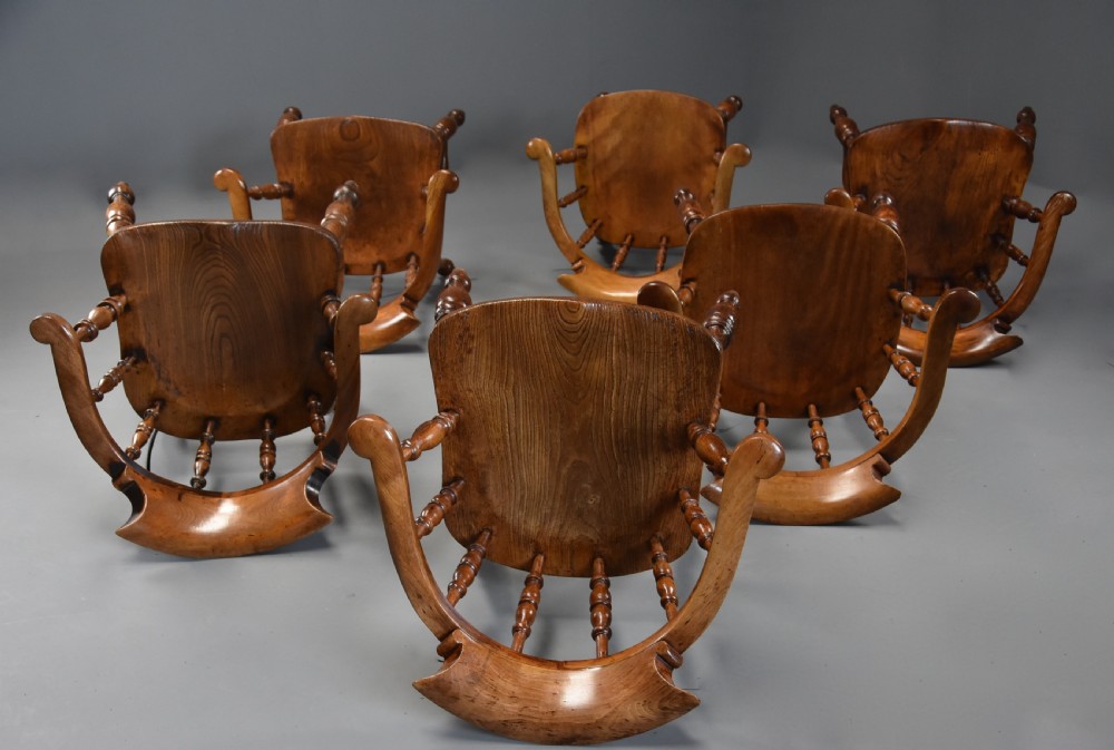 A set of six mid 19th century wooden smokers bow Windsor chairs with curved crest rails, turned spindles, shaped seats, and turned legs with stretchers. View VIII