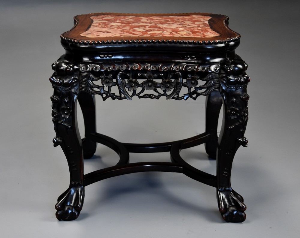 A late 19th-century Chinese dark hardwood low table with a beaded edge, shaped pink marble inset top, pierced carved apron, and cabriole legs terminating in claw feet. View III