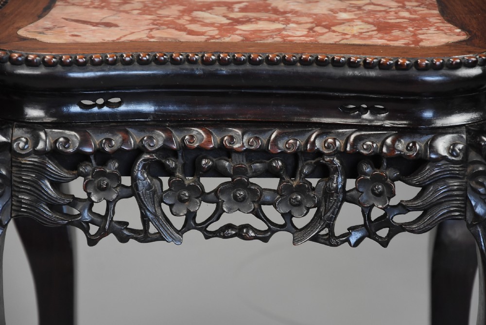 A late 19th-century Chinese dark hardwood low table with a beaded edge, shaped pink marble inset top, pierced carved apron, and cabriole legs terminating in claw feet. View IV
