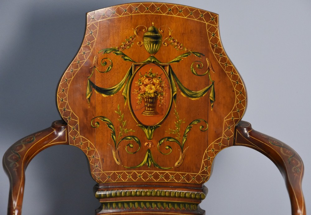 An Edwardian satinwood armchair featuring hand-painted floral swags and an urn motif on a shaped splat back, swept armrests, and an upholstered neutral seat. View V