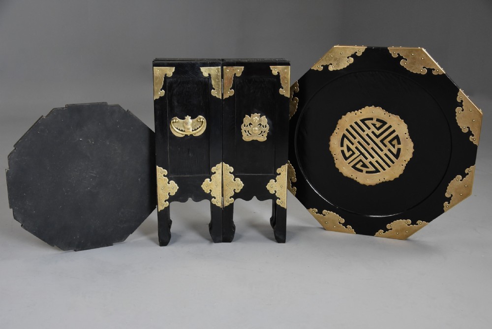 An octagonal ebonised black wood occasional table adorned with etched brass corner mounts, side handles, and a central pierced brass top medallion. View XII