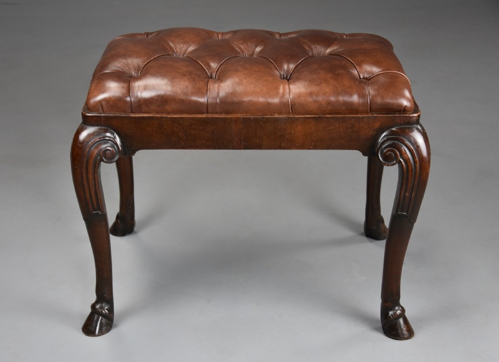 A late 19th-century Queen Anne style walnut stool featuring a deep-buttoned brown leather seat and carved cabriole legs with hoof feet. View IV