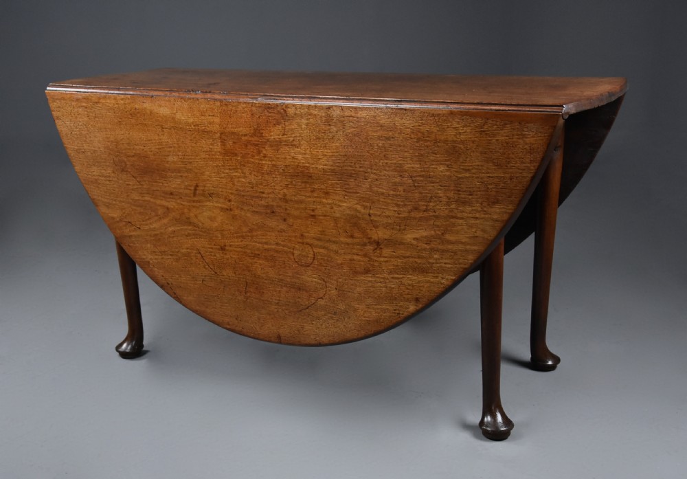 A mid-18th-century solid walnut drop-leaf dining table supported by cabriole legs with pad feet. View II