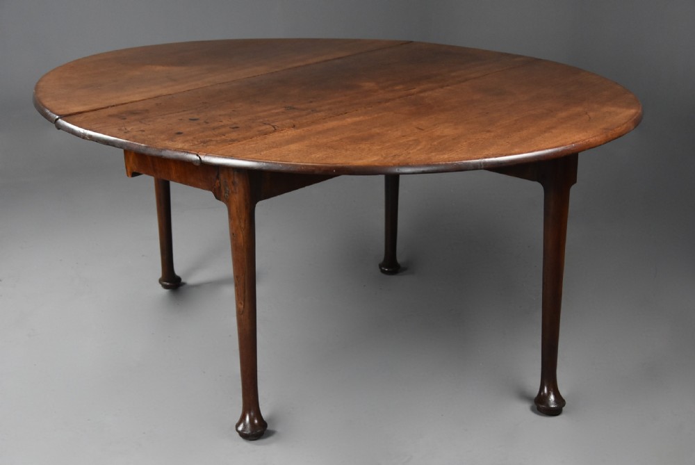 A mid-18th-century solid walnut drop-leaf dining table supported by cabriole legs with pad feet. View V