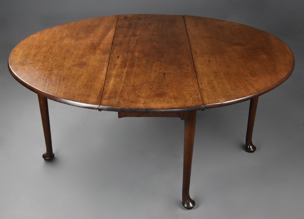 A mid-18th-century solid walnut drop-leaf dining table supported by cabriole legs with pad feet. View VI