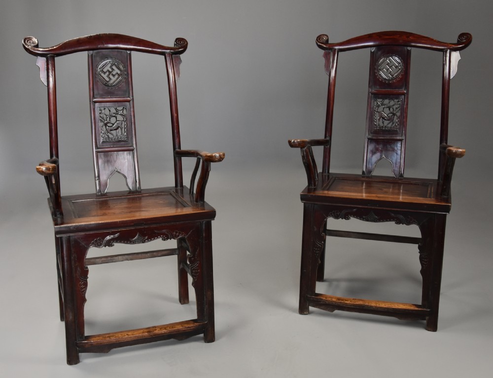 A pair of late 19th-century Chinese armchairs crafted from dark red lacquered elm with shaped yokeback top rails and hand-carved central splats. View III
