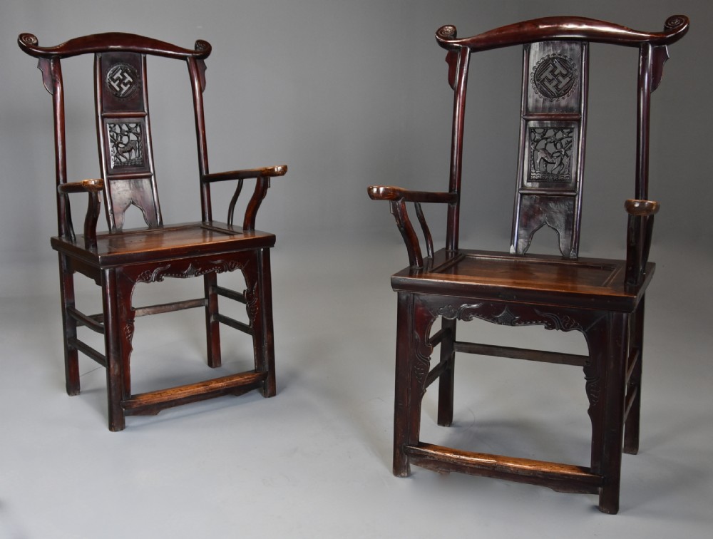 A pair of late 19th-century Chinese armchairs crafted from dark red lacquered elm with shaped yokeback top rails and hand-carved central splats. View IV