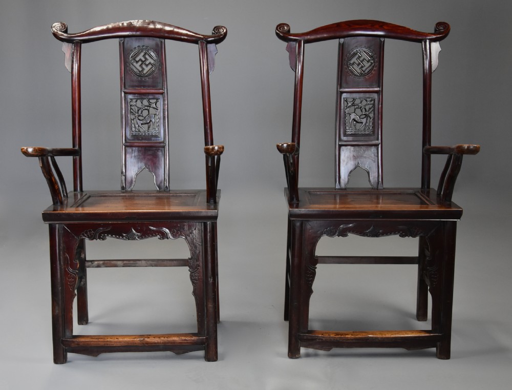 A pair of late 19th-century Chinese armchairs crafted from dark red lacquered elm with shaped yokeback top rails and hand-carved central splats. View VI