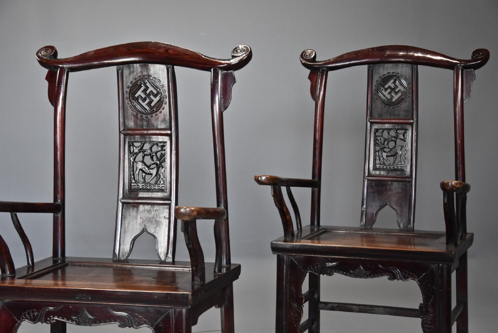 A pair of late 19th-century Chinese armchairs crafted from dark red lacquered elm with shaped yokeback top rails and hand-carved central splats. View VII