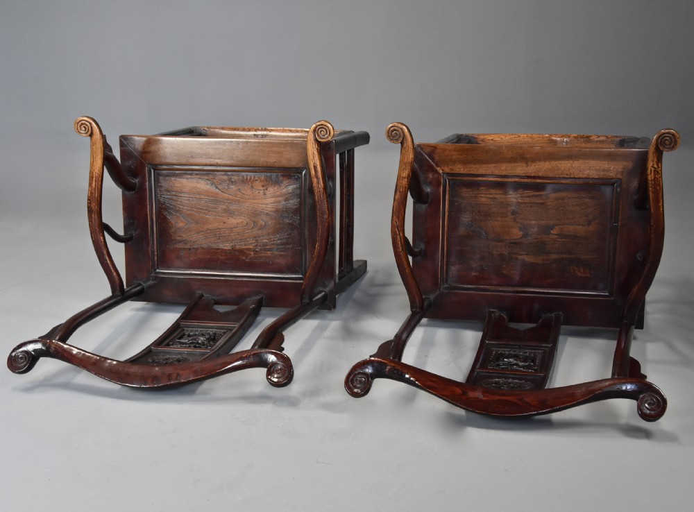 A pair of late 19th-century Chinese armchairs crafted from dark red lacquered elm with shaped yokeback top rails and hand-carved central splats. View VIII