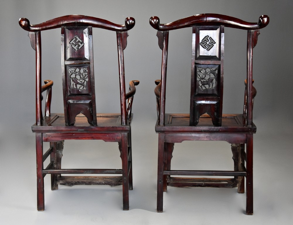A pair of late 19th-century Chinese armchairs crafted from dark red lacquered elm with shaped yokeback top rails and hand-carved central splats. View XI