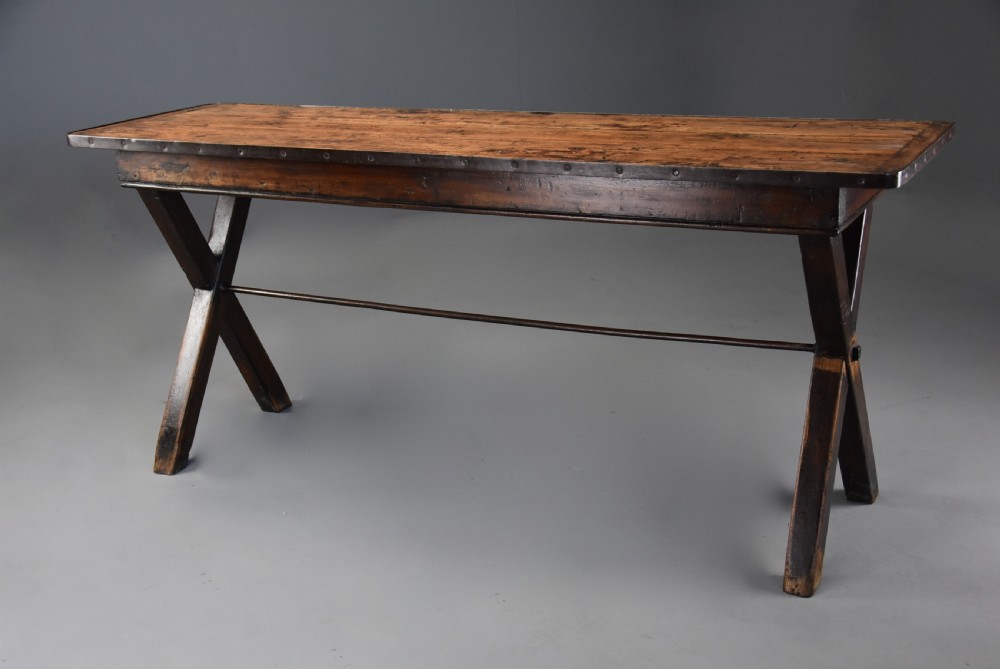 An early 19th-century sycamore tavern table featuring an X-frame trestle base, plank top, and metal stretcher rod. View III