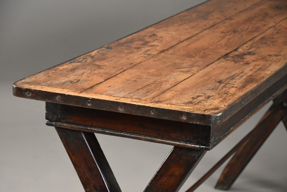 An early 19th-century sycamore tavern table featuring an X-frame trestle base, plank top, and metal stretcher rod. View VIII