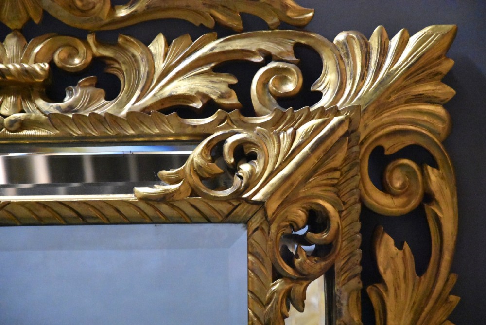 An ornate late 19th-century rectangular Italian giltwood wall mirror featuring a cushion-style frame with secondary glass border panels and carved acanthus leaf scrollwork. View V