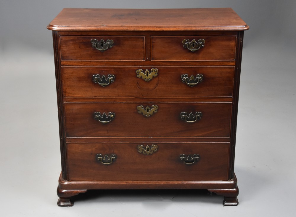 A mid-18th century George III mahogany chest of drawers featuring a two short over three long drawer configuration with brass swan-neck handles and bracket feet. View IV