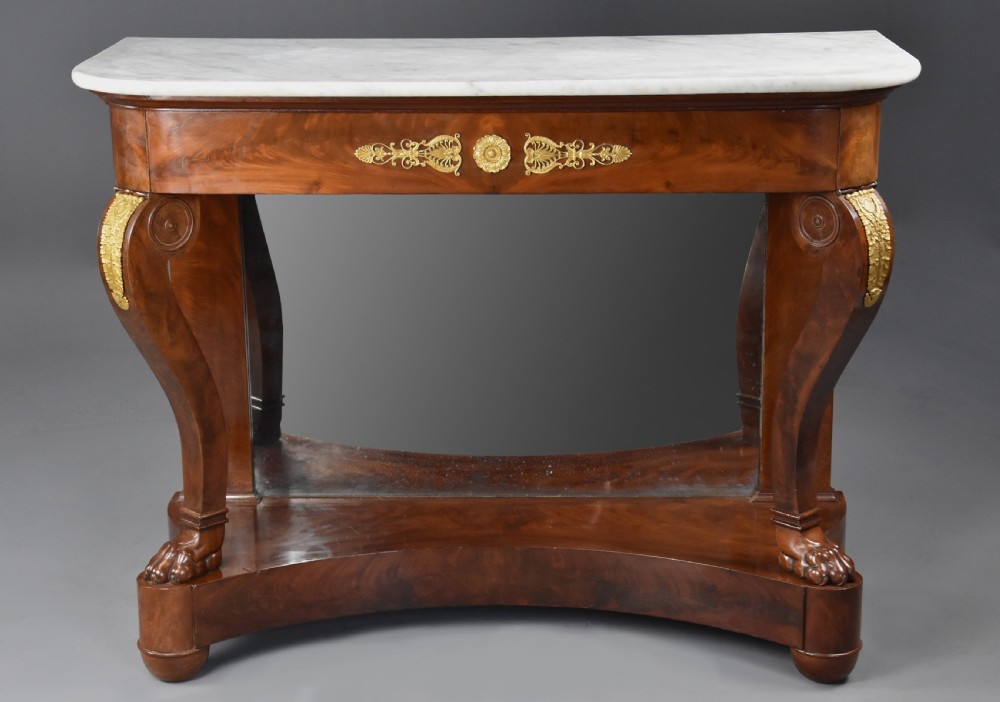 An early nineteenth-century French Charles X mahogany console table with a white marble top, curved front legs ending in paw feet, gilt-bronze mounts, and a mirrored back above a concave base. View IV